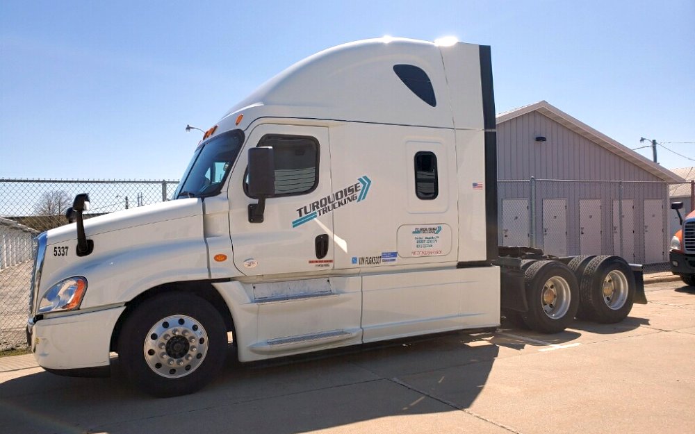 Side view of a white Turquoise truck.